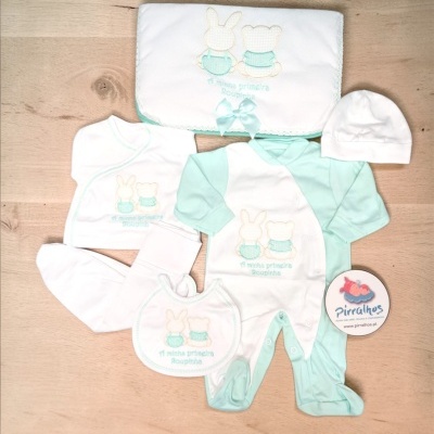 Conjunto de roupa de bebé em branco e verde água com bordados e manta com laço.
