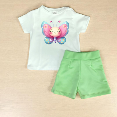 Conjunto infantil com t-shirt branca e calção verde claro sobre mesa de madeira