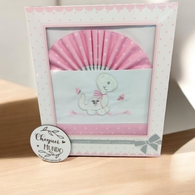Fralda branca bordada com dinossauro e lenço rosa em caixa decorada