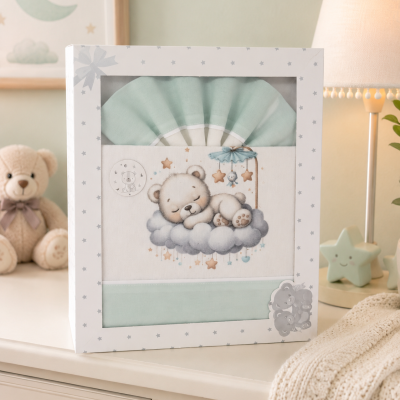 Conjunto de roupa de bebé azul e branco com estampa de urso sobre nuvem na caixa em móvel com lâmpada, urso de peluche e manta