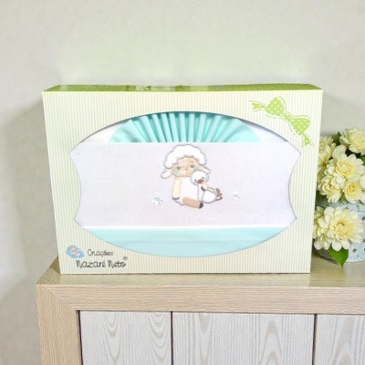Jogo de cama para bebé azul com bordado em embalagem creme com riscas e fita verde