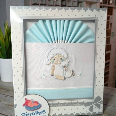 Conjunto de roupa de bebé azul e branco com bordado de carneiro e patinho em embalagem decorada com bolinhas cinzentas