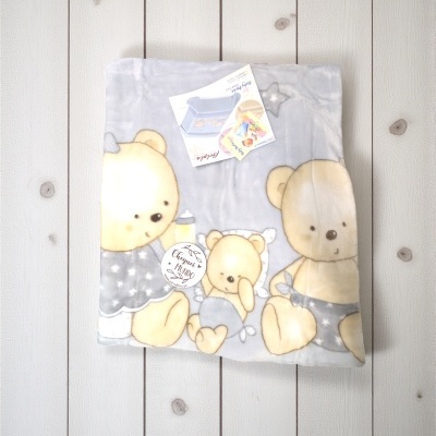 Cobertor cinza com desenho de ursos e etiqueta redonda com texto