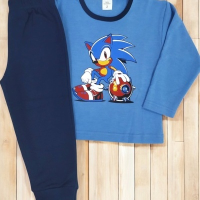 Pijama infantil azul com personagem Sonic e calças azul escuro sobre chão de madeira.