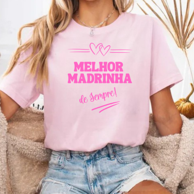 T-shirt rosa com texto em rosa 'MELHOR MADRINHA de Sempre!' e calções de ganga.