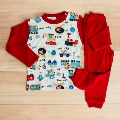 Pijama infantil vermelho com padrão de carrinhos e helicópteros sobre madeira clara