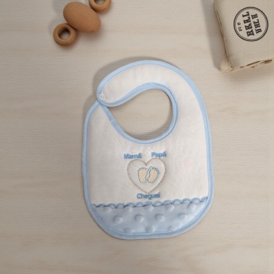 Babete branco com bordas azuis e bordado com texto 'Mamã Papá Cheguei' e pegadas azuis.