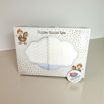 Embalagem branca decorada com estrelas douradas e ilustrações de criança num carrinho com cavalo