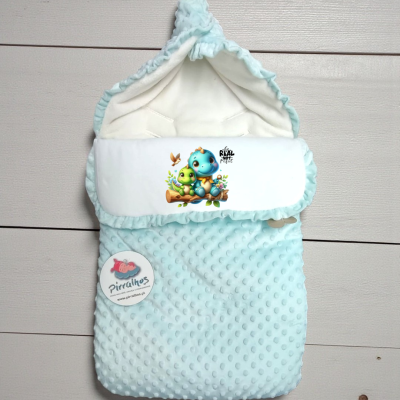 Saco de bebé azul claro com estampa de dinossauros e etiqueta da marca Pirralhos