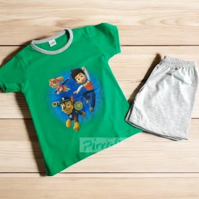 Conjunto infantil com t-shirt verde e calções cinzentos sobre madeira clara