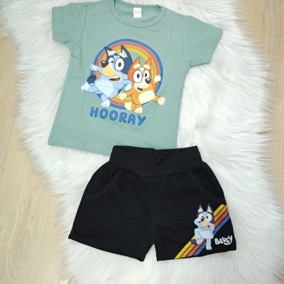 Conjunto de roupa infantil com t-shirt verde água e calções pretos com estampas de cães de desenho animado.