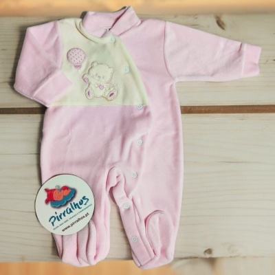 Macacão de bebé cor-de-rosa e creme com ursinho e balão, com botões de pressão, sobre madeira