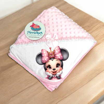 Fralda branca e rosa com imagem de rato com coroa e laço rosa, sobre mesa de madeira