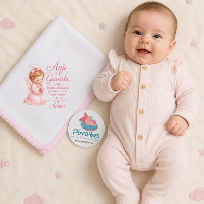 Bebé com macacão rosa claro de malha e fralda branca com mensagem em fundo creme bordado
