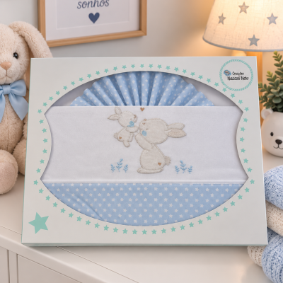 Lençóis de berço azuis com estrelas e bordado de coelhos na embalagem decorada com estrelas.