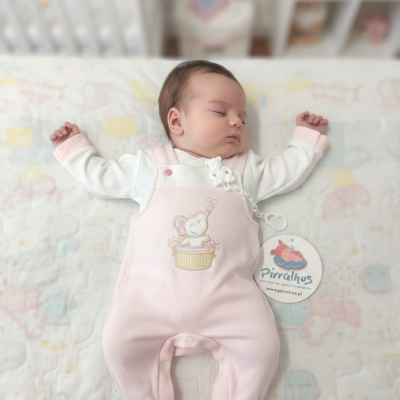 Bebé a dormir com macacão rosa com bordado de elefante e etiqueta Pirralhos em edredão colorido