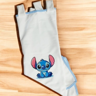 Mangueira de banho infantil branca com bordas azuis e estampa do Stitch sobre madeira clara