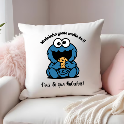Almofada branca com desenho colorido e texto preto num sofá branco com manta creme