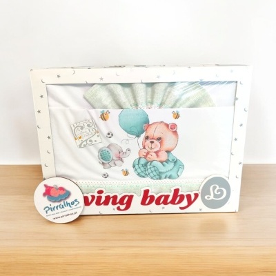 Jogo de cama para bebé com design de ursinho e balão em embalagem branca com estrelas.