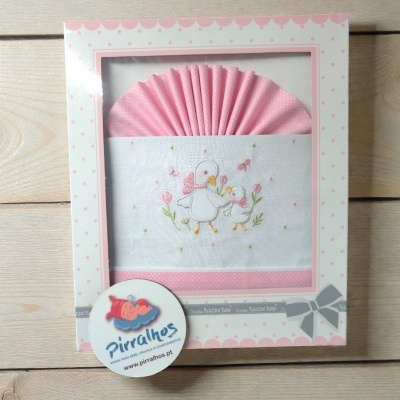 Conjunto para bebé em tecido branco e rosa com bordado de patinhos e embalagem decorativa.