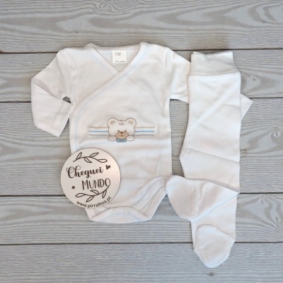 Conjunto de roupa de bebé branco com bordado e etiqueta em madeira clara