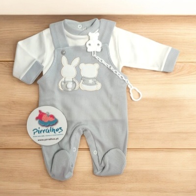 Conjunto de bebé cinza com macacão e body branco sobre fundo de madeira