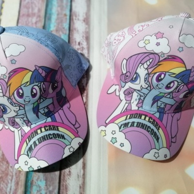 Dois bonés infantis coloridos com desenhos de personagens de desenho animado e arco-íris