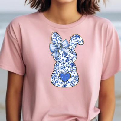 T-shirt rosa com estampa de coelho azul e branco com laço azul e coração azul.