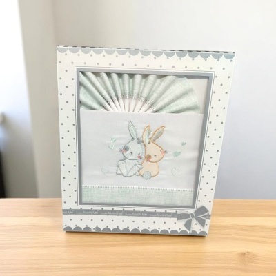 Conjunto de roupa de bebé com bordado de coelhinhos em caixa decorada
