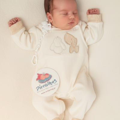 Bebé dormindo com pijama amarelo claro e bordados