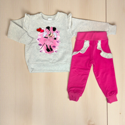 Conjunto de roupa infantil com camisola cinzenta e calças cor de rosa com detalhes em branco no chão de madeira clara