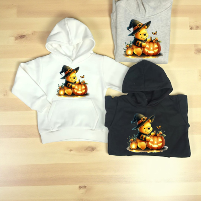 Três sweatshirts com capuz em branco, cinza e preto com estampa de urso bruxo e abóbora iluminada