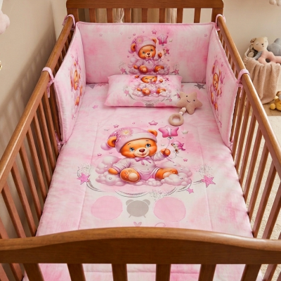 Berço de madeira com roupa de bebé cor-de-rosa com ursinhos e estrelas