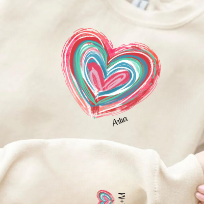 Conjunto de roupa bege com corações coloridos e texto Atriu e A+M