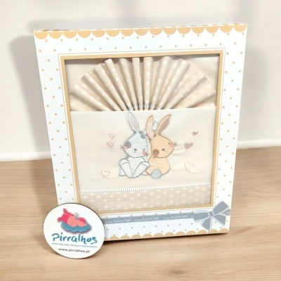 Caixa decorativa com toalha bordada de coelhos e etiqueta de marca