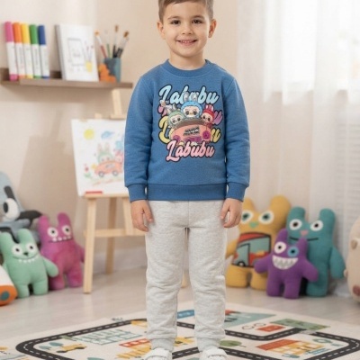 Criança com camisola azul Labubu e calças cinza em quarto infantil com brinquedos e tapete de estrada.