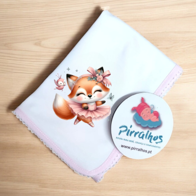 Fralda branca com raposa rosa dobrada sobre superfície de madeira clara