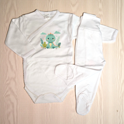Conjunto de roupa de bebé branco com estampa de dinossauro azul e verde numa superfície de madeira clara