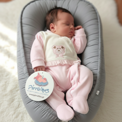 Bebé recém-nascido vestido de rosa em almofada cinza com etiqueta Pirralhos