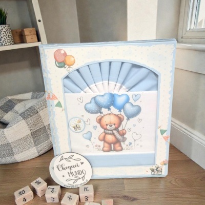 Caixa azul com ursinho e cubos de madeira com letras e números no chão de madeira