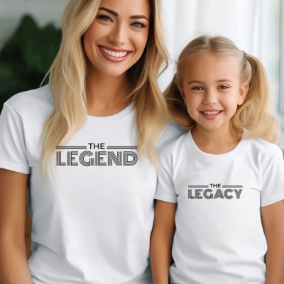 Duas t-shirts brancas com texto preto e pessoas sorrindo em ambiente interno iluminado