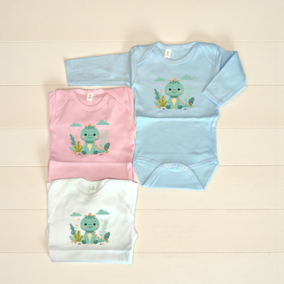 Três bodies de bebé azul, rosa e branco com estampa de dinossauro