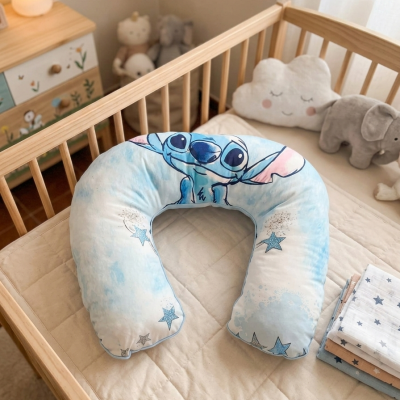 Almofada de bebé em forma de U com estampa Stitch azul em cama de madeira clara