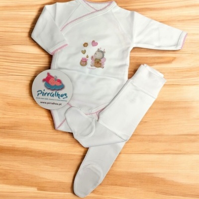 Conjunto de bebé branco com detalhes rosa e ilustração, calças com pés, etiqueta Pirralhos, fundo madeira clara