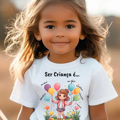 Camisola branca infantil com estampa colorida de menina e balões com texto em português.