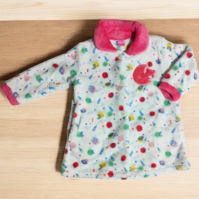 Casaco infantil branco com padrão colorido, gola e punhos rosa, aplique vermelho no peito