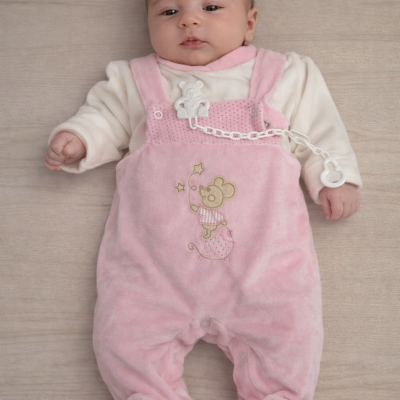 Bebé deitado com macacão rosa e camisa branca