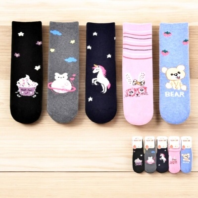 Cinco pares de meias coloridas infantis com desenhos variados e fundo de madeira clara