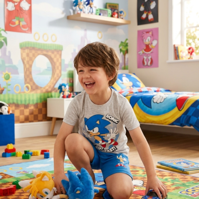 Criança num quarto decorado com tema Sonic com tapete, roupa de cama, peluches e posters da personagem.