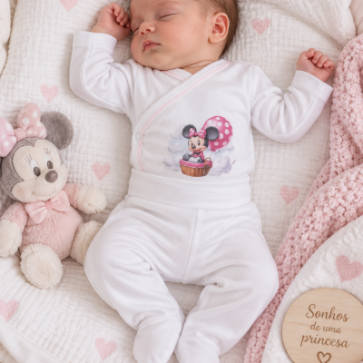 Bebé a dormir com pijama branco com Minnie e balão, peluche da Minnie, manta rosa e placa de madeira Sonhos de uma princesa.
